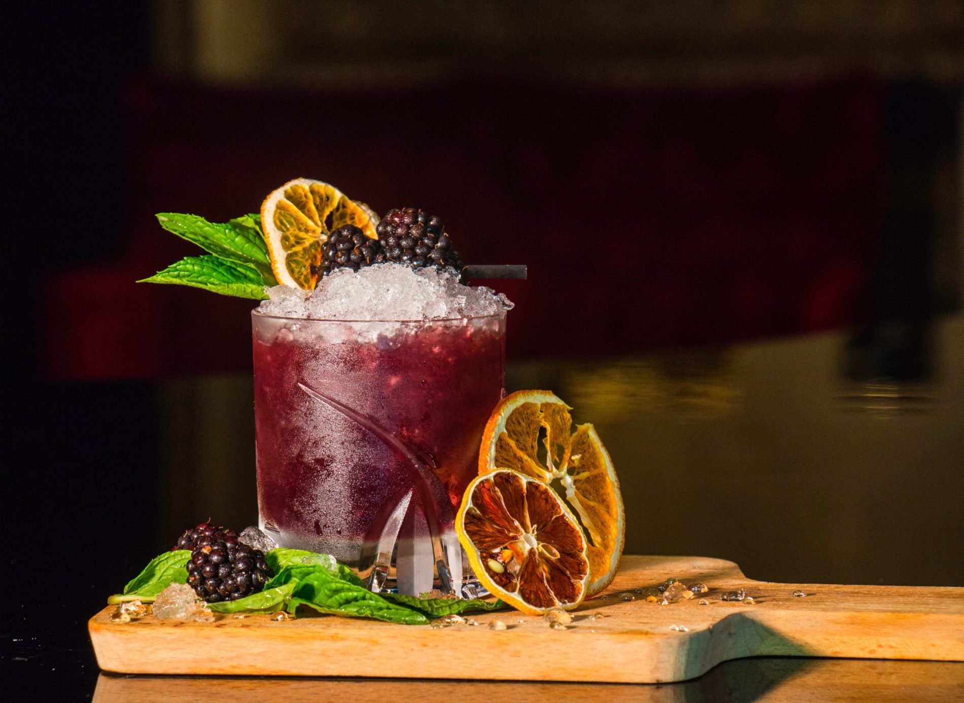 berry cocktail with blackberry, mint and citrus garnish